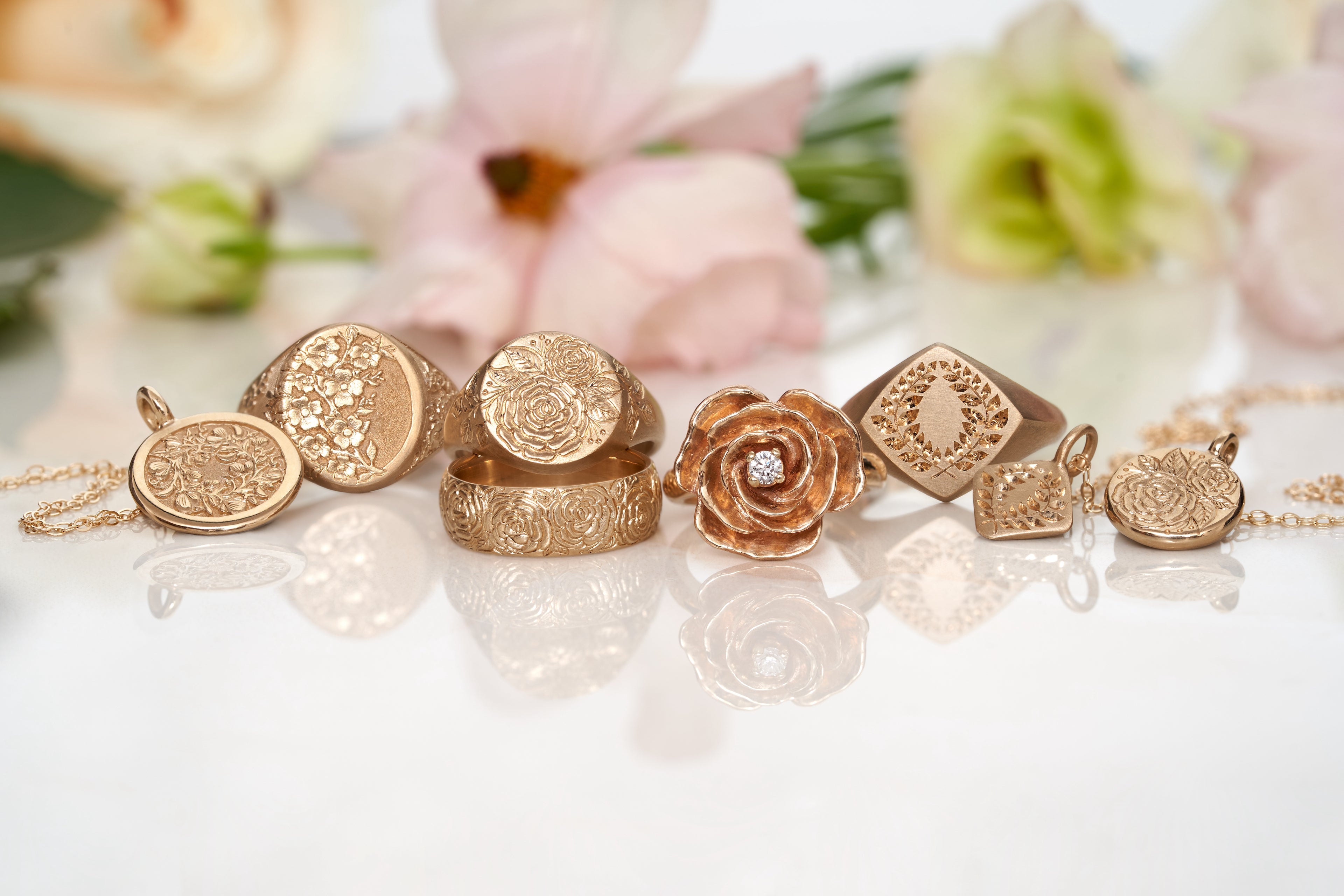 gold rings on a white backdrop with unfocused flowers in the background